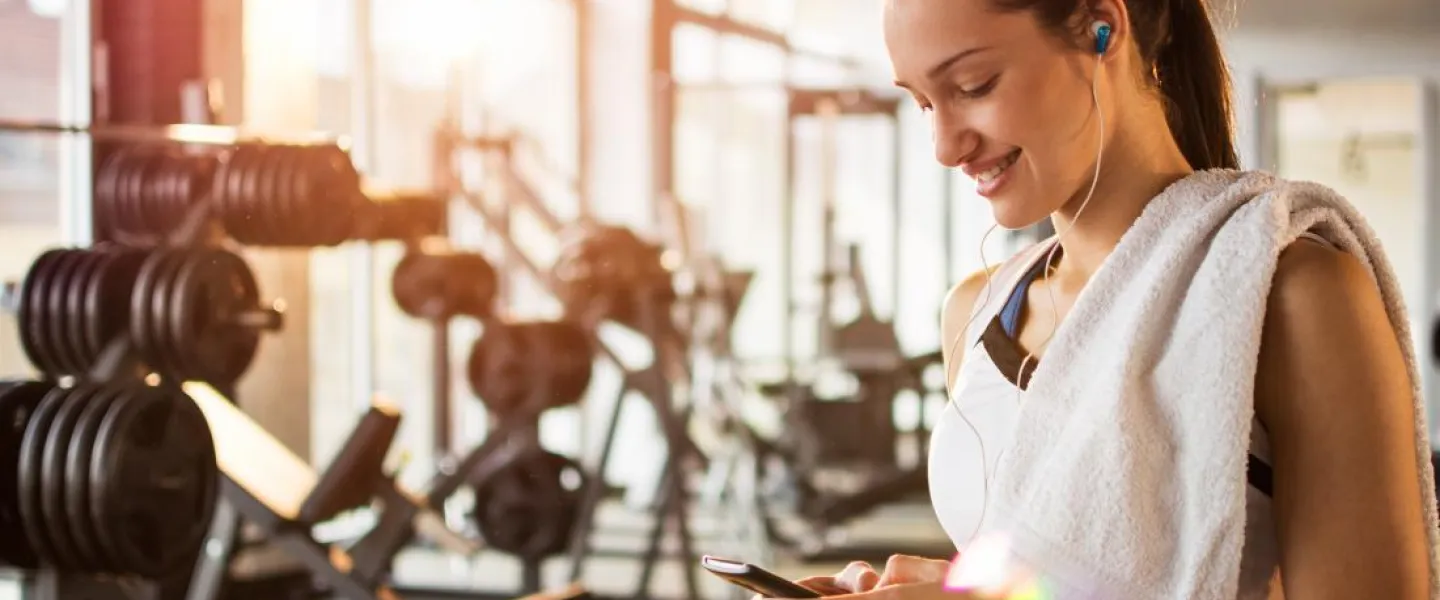 Woman looking at her phone at the gym