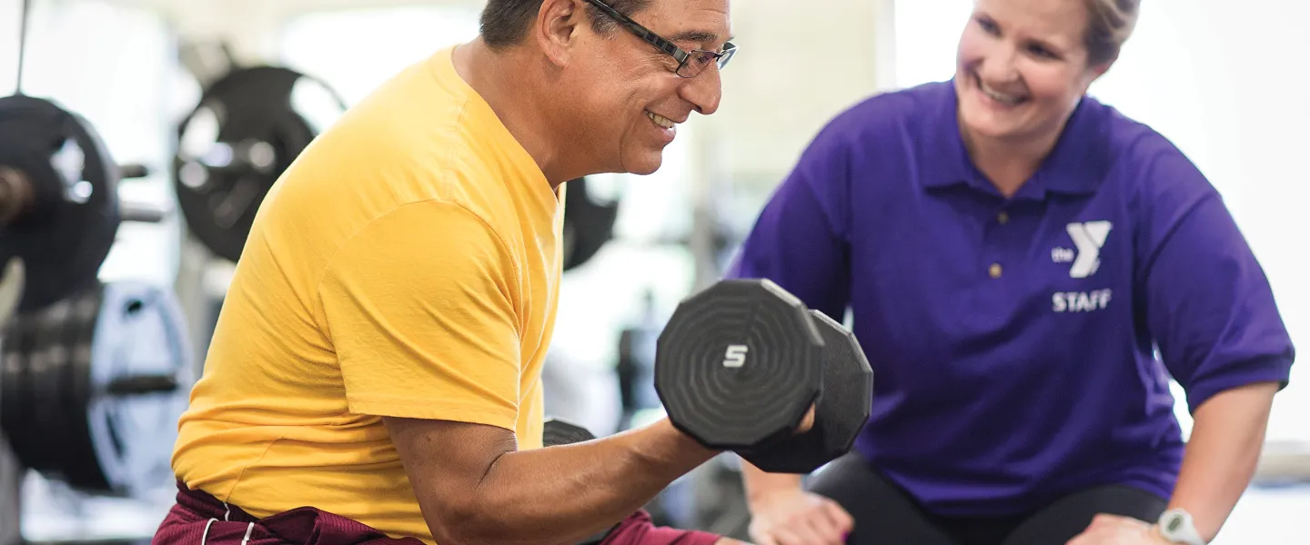 Staff member watching man workout