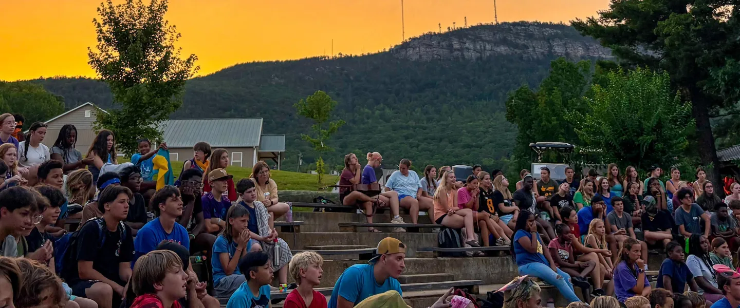 view of campers at campfire with the mountain view in the background