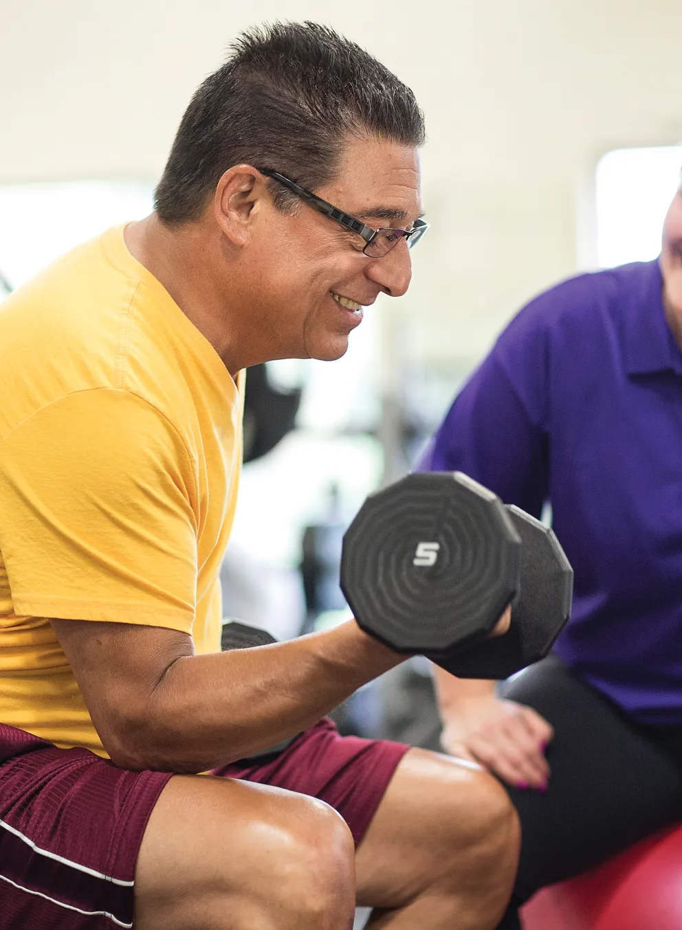 Staff member watching man workout