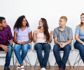 Young adults sitting in chairs and talking