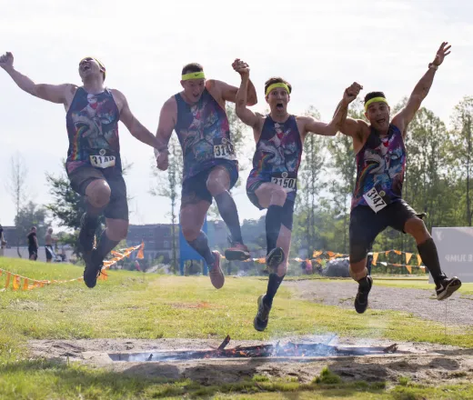 Men running the Dirty Dozen Mud Run and jumping