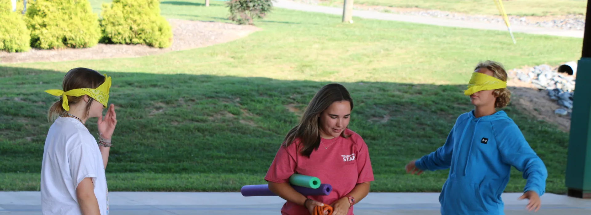 Two students facing each other with Camp Hanes staff in the middle.