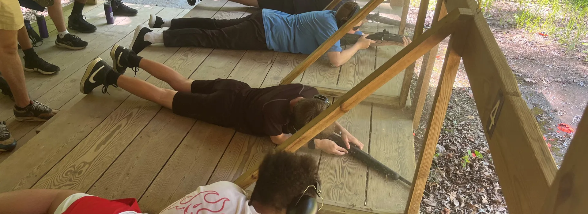 Boys shooting rifles prone